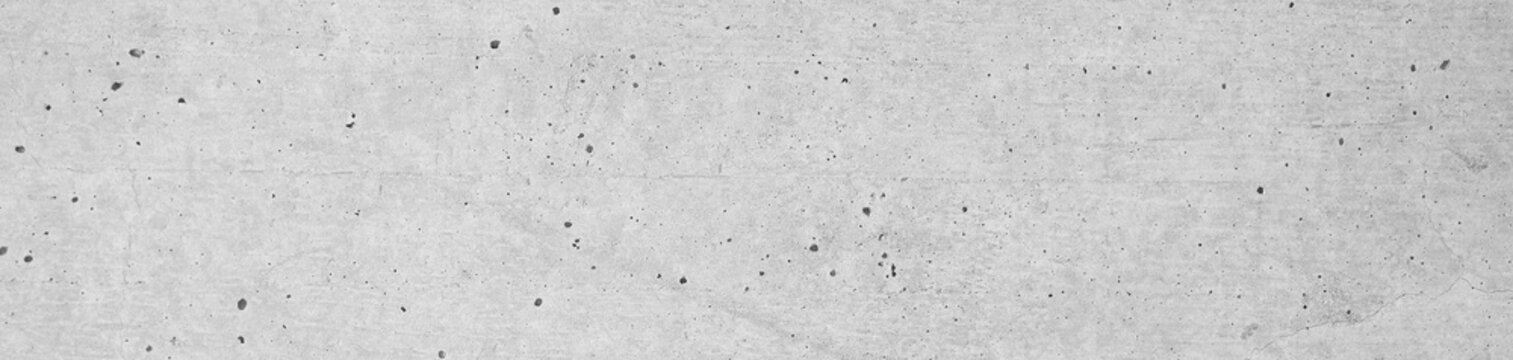 Concrete wall with holey structure in widescreen format. Horizontal cement wall with slightly rough plastering.