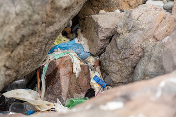 garbage on the beach among the rocks. stop plastic