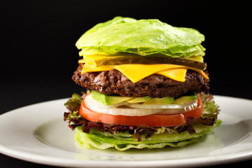Burger with vegetables and lettuce burger with onion and tomato, dark background. lettuce leaf on...