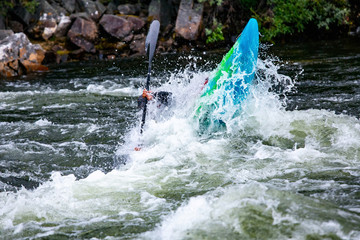 Guy in kayak sails mountain river. Whitewater kayaking, extreme sport rafting