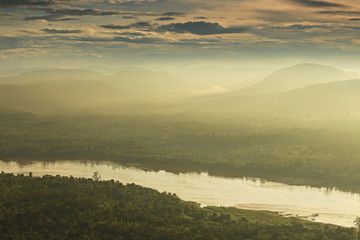 Panorama viewpoint at Pha Chanadai has thick fog in the morning. See the sun shine through the mountain peaks of Laos