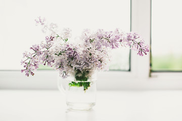 beautiful lilac flowers on the window in a vase, background - 350935264