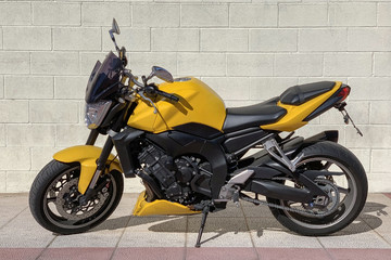 Obraz na płótnie Canvas yellow sport motorbike on the background of brick wall