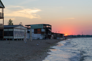 Sunrise over sea beach with slum campsite