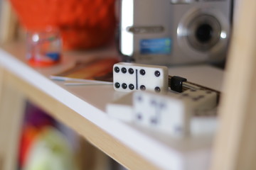 Variation of different objects including a camera and red glass box 
 and Wristwatch and flowers and domino on white background at home with nice depth and blur