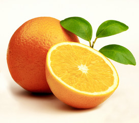 Whole & Half Oranges with leaves against white background