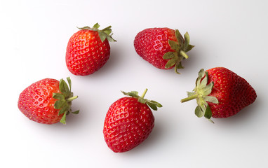 Study of 5 strawberries with stalks against a white background