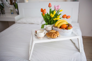 breakfast on a tray in a white bedroom