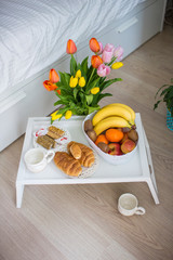 breakfast on a tray in a white bedroom