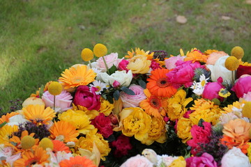 Gelbe Blumen im Blütenkranz nach Beerdigung auf dem Friedhof 