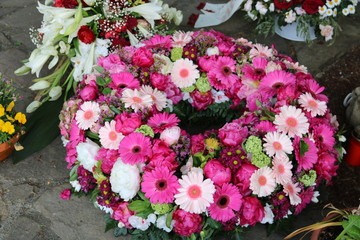 Runder Blumenkranz nach Beerdigung auf dem Friedhof in Pink