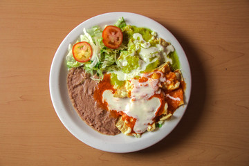 Chilaquiles rojos y verdes con frijoles y lecuhga