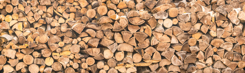 panorama. pattern of firewood. light wooden background