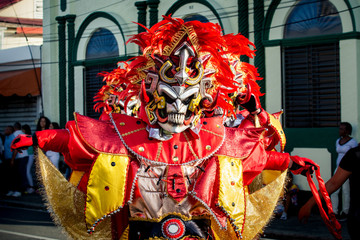 closeup man in vivid costume poses for photo on city street at dominican carnival