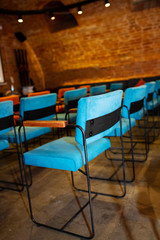 Red and blue chairs in the dark hall of a small cinema