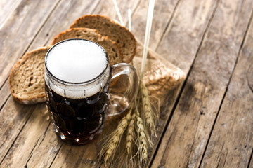 Traditional kvass beer mug with rye bread on wooden table. Copy space