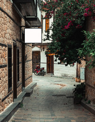 Narrow street in Antalya&rsquo;s old town with rectangular billboard White mockup on the wall. Old town in city centrum is a must see place for tourists during their visit to Antalya.