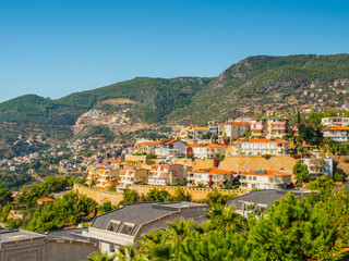 Fototapeta na wymiar Alanya, Turkey. Beautiful view new houses on the mountain. Real estate. Vacation postcard background