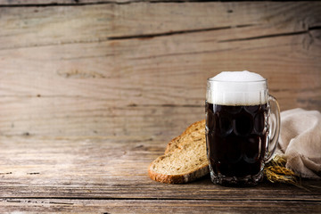 Traditional kvass beer mug with rye bread on wooden table. Copy space
