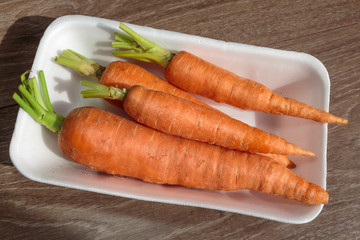 Tasty ripe carrots in a plastic package. Ready for sale. Vegan food. Business concept.