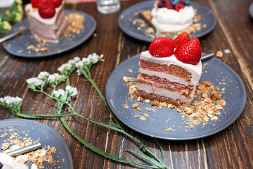 Sweet cakes with summer berries on a wooden table. Party, sweet table. Summer offer desserts in the restaurant.
