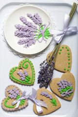 Gingerbread cookies decorated with glaze. Gingerbread cookies in the form of a heart. Near a bouquet of lavender.