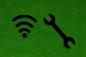 Wi-Fi sign. the spanner is black on a green background. Repair and configuration of technological...