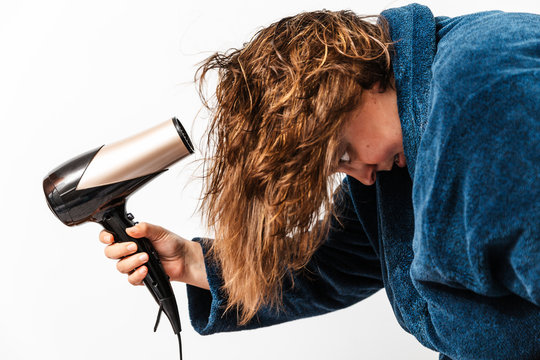 es una mujer.  de 40 a&ntilde;os y sobrepeso cauc&aacute;sica con pelo moreno lleva un secador en la mano para secar su cabello mojado. lleva un albornoz azul.