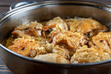 Appetizing tasty fried chicken thighs in a pan, close-up, shallow depth of field, selective focus. Homemade food concept.