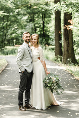 Naklejka premium wedding couple in the park,European bride and groom kissing in the park,happy bride and groom at a park on their wedding day
