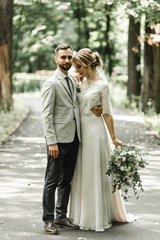 Naklejka premium wedding couple in the park,European bride and groom kissing in the park,happy bride and groom at a park on their wedding day