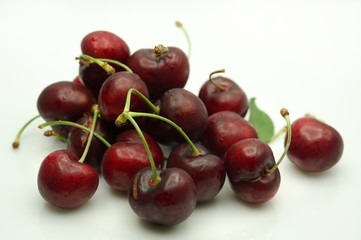 puñado de cerezas maduras sobre fondo blanco