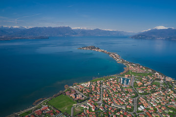 Sirmione town, Lake Garda, Italy. Aerial view of Sirmione high altitude.  In the background mountains in the snow and blue sky.