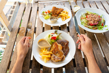 First-person view of a guy eating food in a summer cafe.