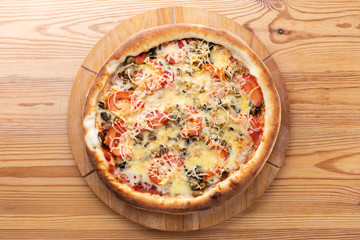 hearty italian pizza on a wooden board. .meat pizza with beef, fresh tomatoes, mushrooms and grated cheese