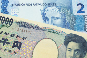 A macro image of a Japanese thousand yen note paired up with a blue two real bank note from Brazil.  Shot close up in macro.