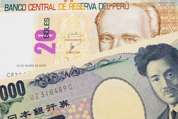 A macro image of a Japanese thousand yen note paired up with a beige, twenty sol bill from Peru.  Shot close up in macro.