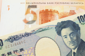 A macro image of a Japanese thousand yen note paired up with a orange five ruble bank note from Belarus.  Shot close up in macro.