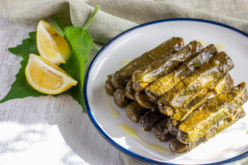 Traditional turkish meal - Yaprak sarma. Grape leaves stuffed withrice and spices. Served with olive oil and fresh lemon