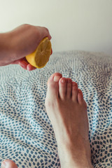 hand with a lemon and a young foot