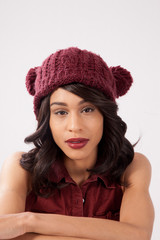 Pensive woman in a red knit cap