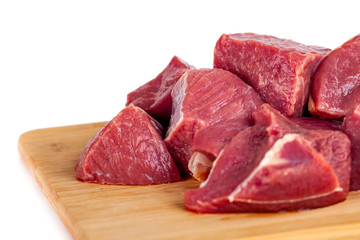 Chopped raw meat on wooden board isolated on white background