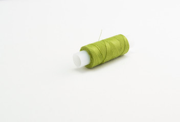 a spool of green sewing thread on a white background