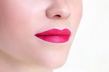 Fototapeta premium Young woman having permanent makeup on her lips at the beauticians salon. Permanent Makeup (Tattoo). drawing a contour with a white lip pencil