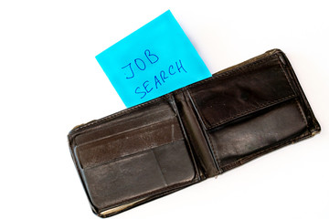 Flat lay. Notebook with job search phrase and open old shabby empty wallet purse, on white background. Searching a work, last money, poverty, unemployment, job loss concept.