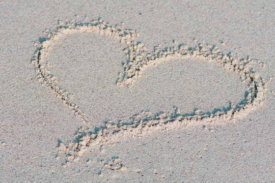 Heart drawn on the sand. Love, summer and holidays concept