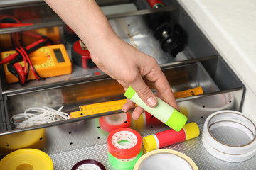 Man taking glue from drawer indoors, closeup