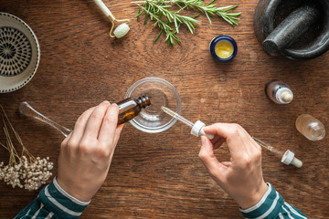 Woman's hands mixing skin care ingredients to create bespoke beauty products and treatments.  Beauty skin care and wellness background with top down view in flat lay style