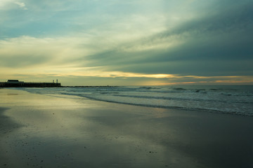 Beautiful sunset on the North Sea with pier and lighthouse in the background