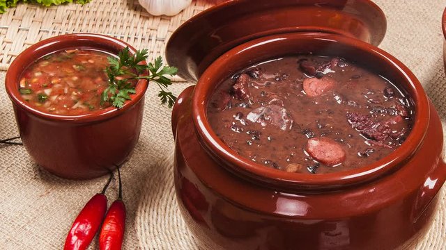 Slide shot Brazilian feijoada on the table with smoke in slow motion